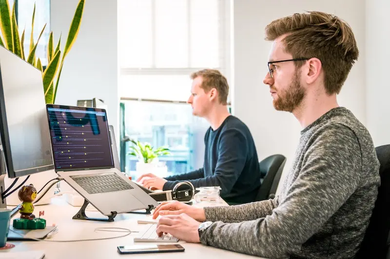 Custom software programmers working at desk, coding