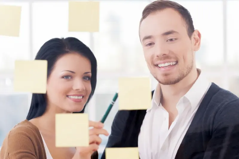 woman and man looking at post-it notes