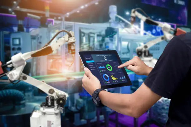 automotive industry person controlling machinery with tablet