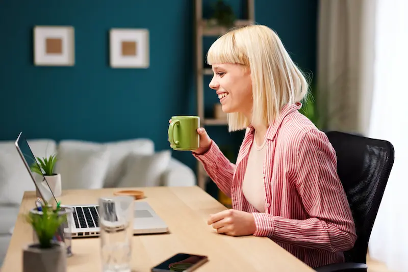 personalised recommendations woman having hot drink at laptop