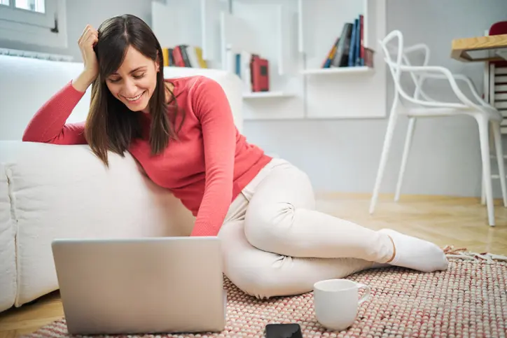 woman-working woman working on laptop on rug on floor