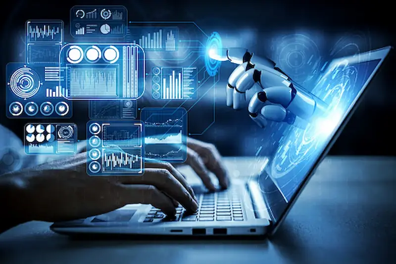 AI hand robot hand reaches out of laptop screen to touching floating holographic tech images while human hands type on keyboard