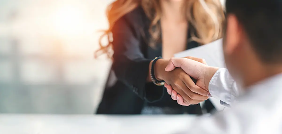 Two office workers shaking hands